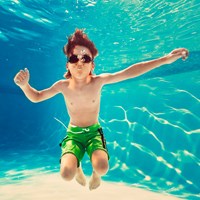 Boy with swimming goggles on swimming underwater